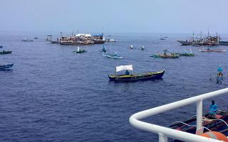 Fishing boats carrying Filipino activists and volunteers head towards a disputed shoal in the South China Sea (Philippine Coast Guard via AP)