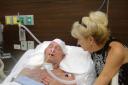 Tender touch – Mr Ayling’s mother, Anita, comforts him as he lays in a coma in Thailand