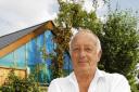 Angry – Robert Gray in his garden with his neighbour’s shed  towering above him