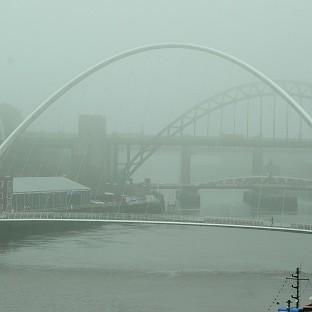 People walk through fog to cross the Tyne Bridge in Newcastle upon Tyne
