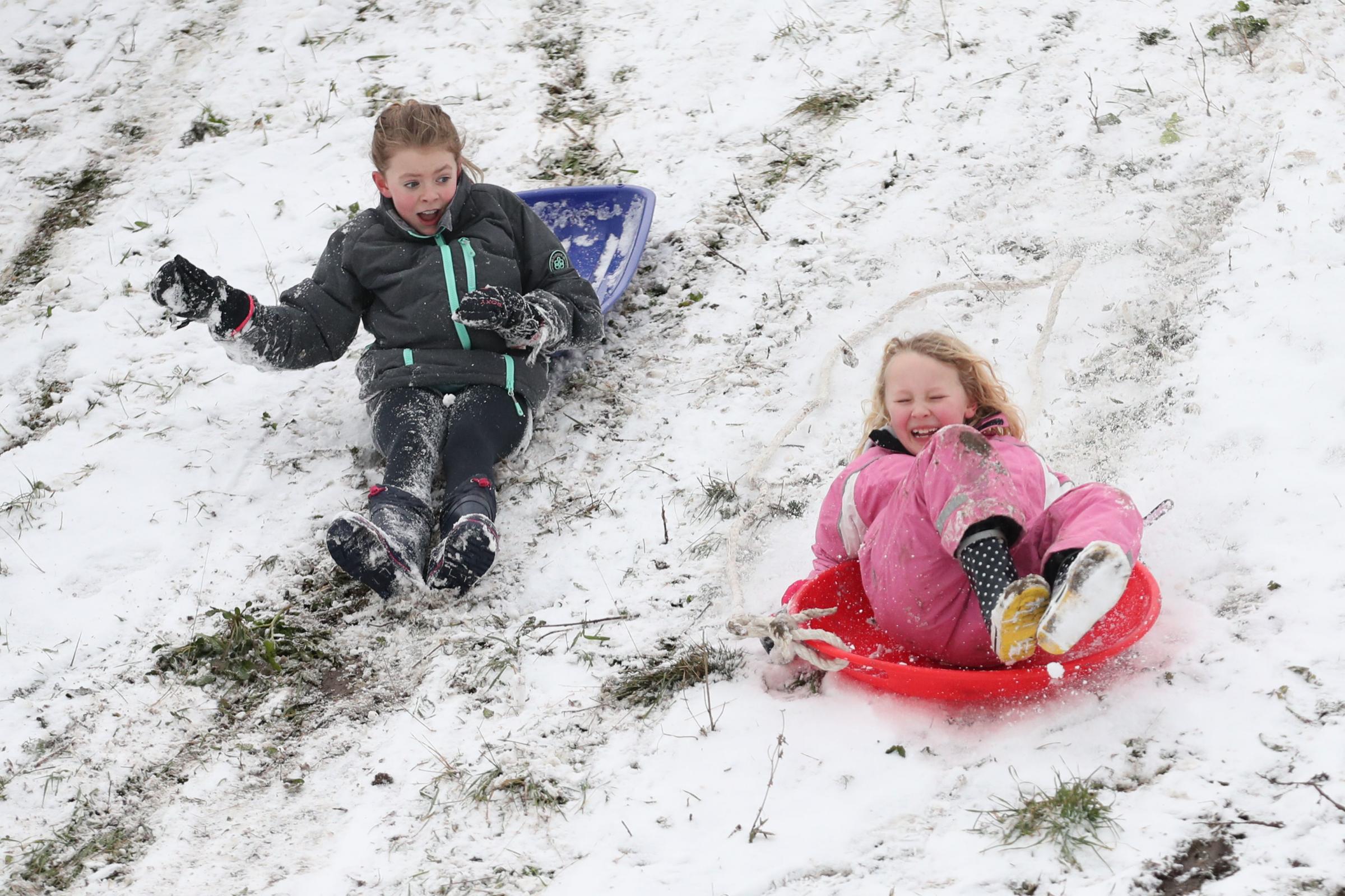 Amy Heather, aged 10 (left) and Betty Smith, aged 7, sledging near the seafront at Southend. Picture: Yui Mok/PA Wire