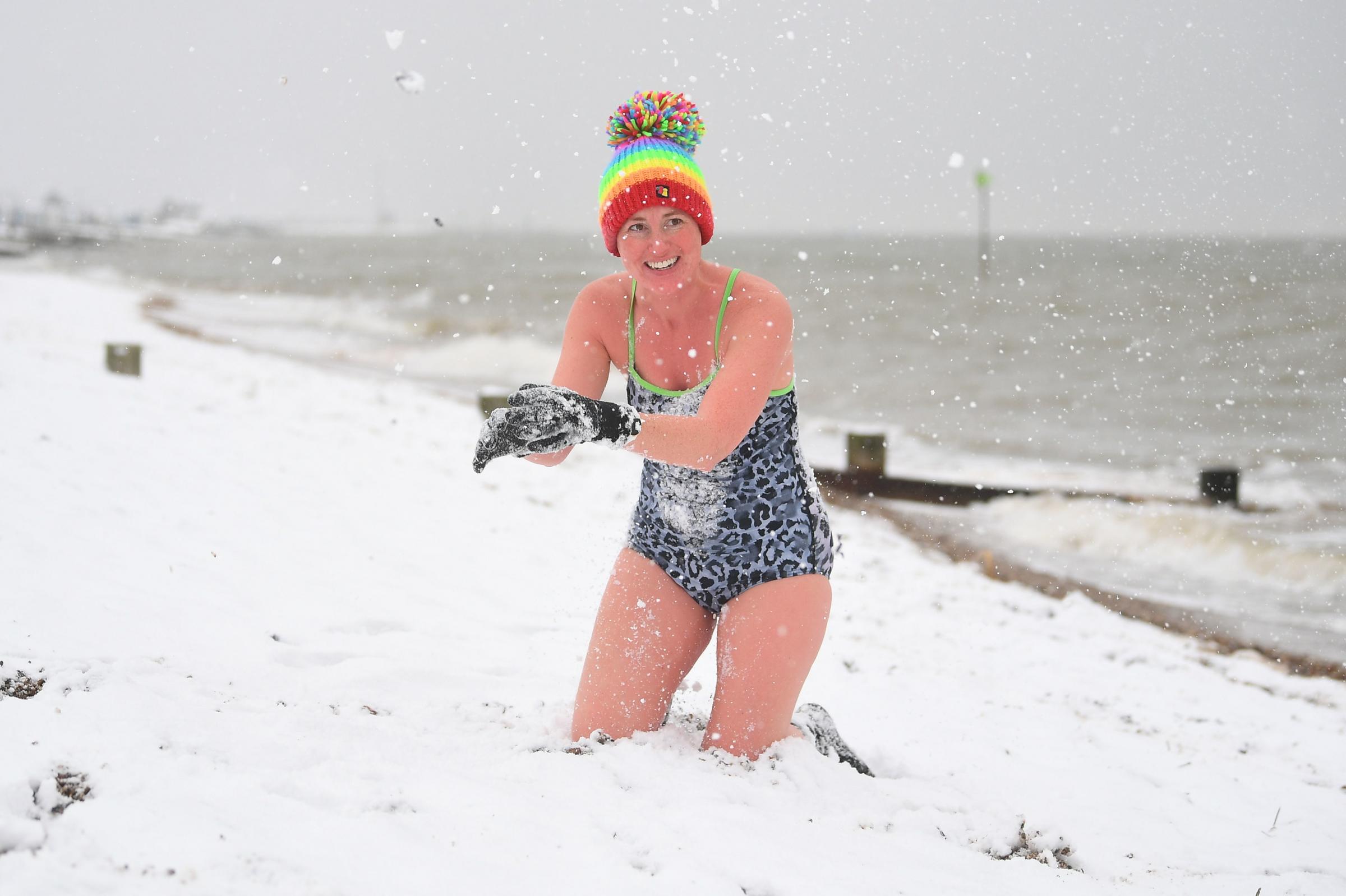 Swimmer Victoria Carlin plays with the snow at the beach in Thorpe Bay. Picture: Victoria Jones/PA Wire 