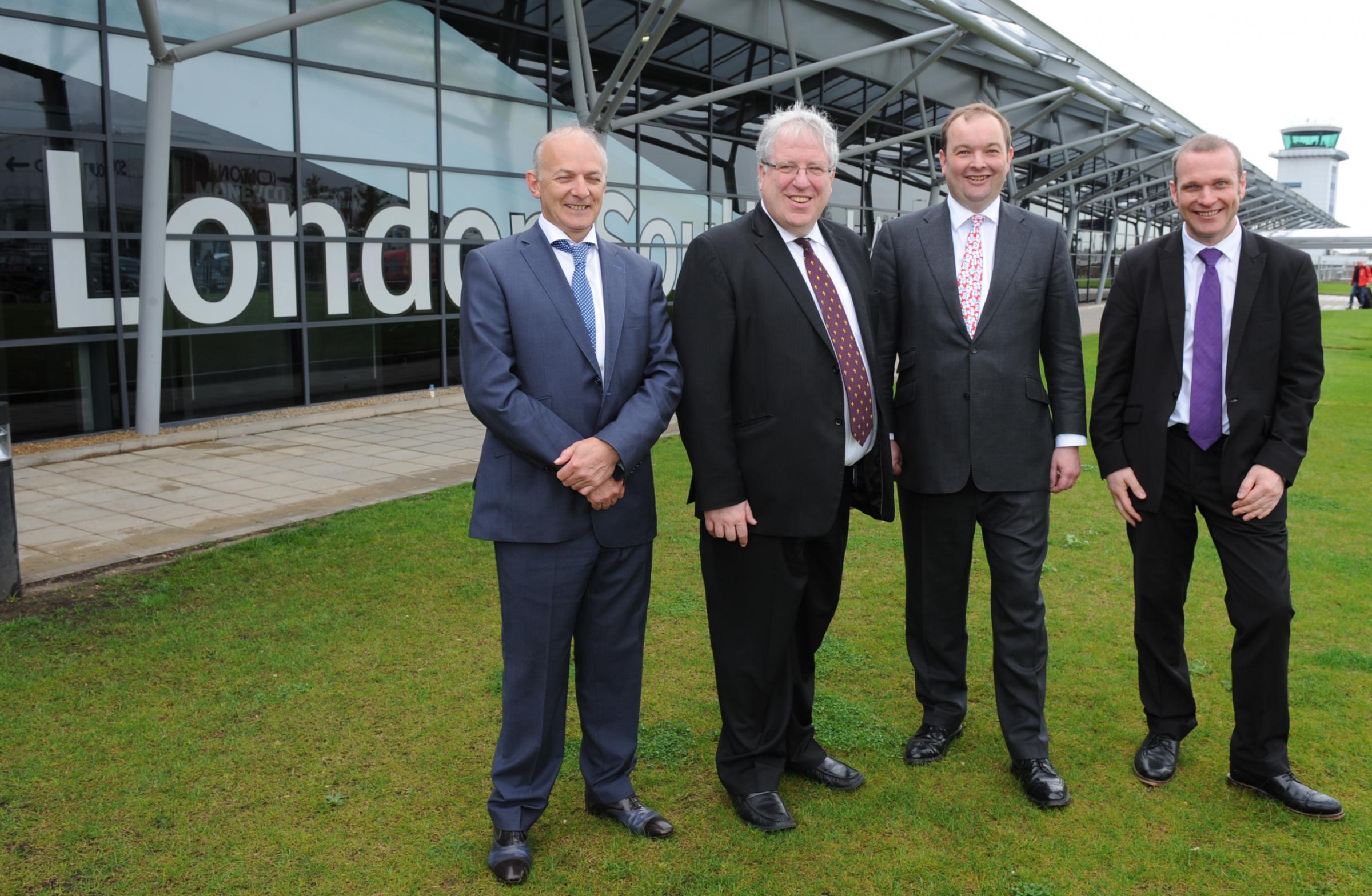 All smiles - transport secretary Patrick McLoughlin (second from left) opened a new extension to the airport in April 2014