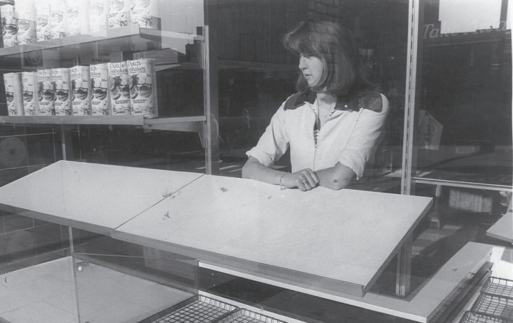 Empty shelves - a bakery worker looks out amid the bread shortage of 1977