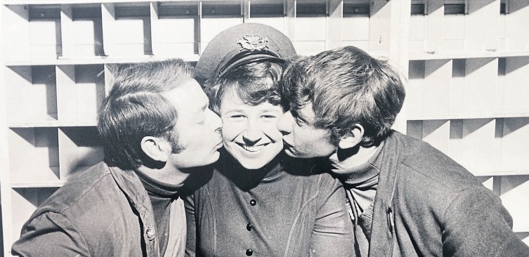 Cheeky - Post Office worker Penny Ravencroft gets an affectionate kiss on the cheek from two work colleagues in December 1970