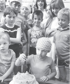 Slice - youngsters cut a celebratory cake at a party