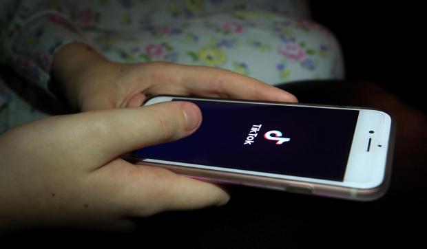 Echo: A person using TikTok on their phone. Credit: PA