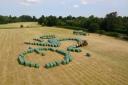 Big job! The team putting together the bales of hay to form the cyclist in the field sculpture
