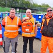 Three members of the Veolia staff at Stock Road HWRC with a new defibrillator